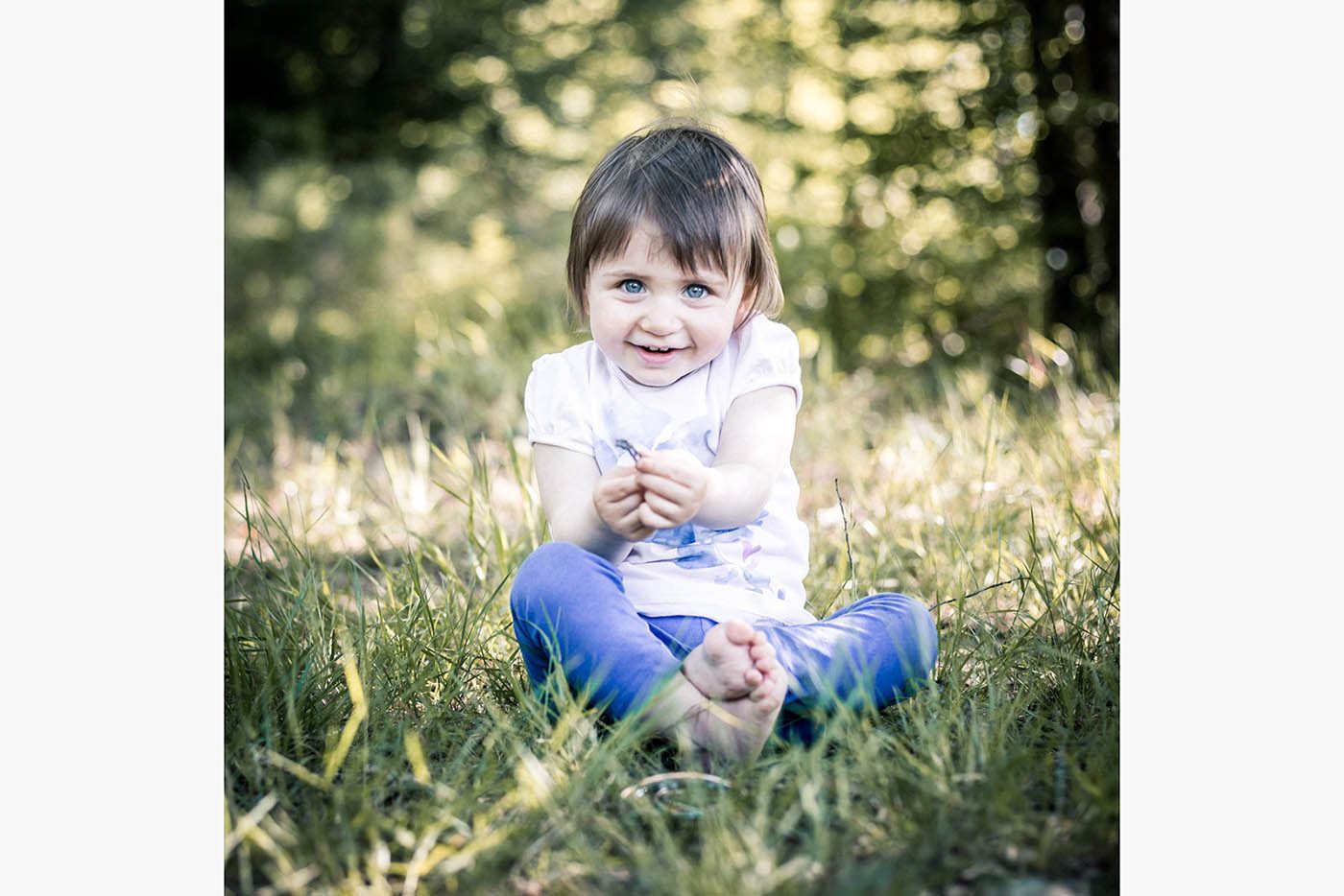 Le regard malicieux d'une petite fille qui s'amuse en forêt, à Bouconne